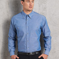Man wearing chambray blue long sleeve shirt with button-down collar, dual chest pockets and snap buttons