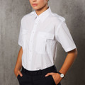 White short sleeve epaulette shirt with twin chest pockets and button front, worn by female model with black trousers