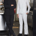 Black and white stretch chef pants with elastic waistband shown in commercial kitchen setting