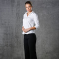 Woman wearing white mini herringbone 3/4 sleeve shirt with V-neck collar and concealed placket, paired with black trousers