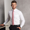Man wearing white self-stripe long sleeve dress shirt with chest pocket and pink tie, styled with black trousers