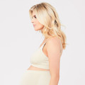 Model wearing a natural cream seamless nursing bra with thin adjustable straps, side profile view