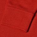 Bright red long sleeve polo shirt showing ribbed cuff and pique knit texture detail
