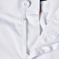 White cargo work pants showing zippered pocket detail with orange contrast trim and button closure