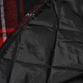 Black quilted lining detail of flannel shirt jacket with red and white plaid exterior visible at edge