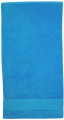 Bright blue cotton velour beach towel with horizontal stripe detail near hem