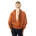 Back view of burnt orange half-zip hoodie with hood up, ribbed cuffs and hem visible on blonde model