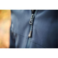 Close-up of navy softshell jacket showing branded zipper pull and chest pocket stitching detail