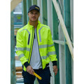 Man on construction site wearing fluoro yellow hi vis softshell bomber jacket with navy trim and reflective tape