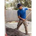 Man shovelling dirt outdoors wearing a Royal blue short-sleeve tee with reflective piping detail