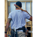 Tradie on construction site wearing light grey marle cotton tee, rear view showing small chest logo print