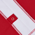 Close-up of red and white contrast panel raglan polo shirt showing tonal button placket and overlock stitching detail