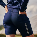 Navy stretch ripstop cargo shorts on female model, rear view showing reflective zip pocket detail and waistband