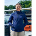 Navy softshell jacket with chest pocket and contrast grey piping detail worn by woman outdoors