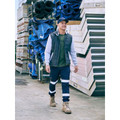 Navy stretch denim cargo pants with silver reflective tape at knees and calves, worn with boots in warehouse