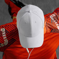 White laser-cut perforated running cap with structured crown, worn by athlete in orange jersey, overhead angle