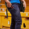 Navy blue women's cargo pants with multiple pockets and knee panels, paired with bright blue top