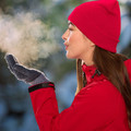 Woman in red jacket wearing a red ribbed knit roll-up beanie in an outdoor winter setting