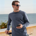 Man in slate grey premium long sleeve crew neck tee, coastal outdoor setting with bicycle