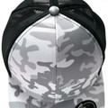 Close-up of snow camo trucker cap with grey and white camouflage front panels and black mesh back