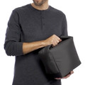 Black insulated cooler bag being held, showing smooth exterior and carry handles with charcoal henley shirt