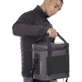 Man opening charcoal Stormtech leak-proof soft cooler bag with zip pull, shoulder strap and structured panels visible
