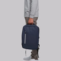 Navy blue water resistant backpack with contrast grey front zipper pocket held by person
