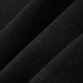 Close-up of black organic cotton fabric showing fine ribbed texture and soft drape