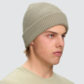 Sage green ribbed cable knit beanie with rolled cuff, worn to show snug fit and textured knit detail