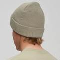Sage green cable knit beanie with rolled cuff shown from behind on model