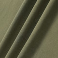 Sage green pique polo fabric showing fine textured knit construction with soft draping folds