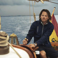 Navy softshell jacket with stand collar and chest pocket worn on boat deck