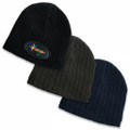 Three cable knit beanies in black, charcoal grey, and navy blue with ribbed texture and turned-up cuffs