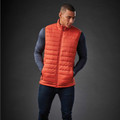 Orange quilted puffer vest with navy long sleeve base layer, featuring full zip and horizontal channel stitching