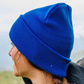 Royal blue acrylic cuffed beanie with ribbed fold-up cuff worn by model outdoors