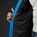 Close-up of black softshell jacket interior showing electric blue zip trim and welt hand pocket