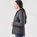Woman wearing charcoal quilted thermal jacket with snap-adjustable waist, side profile view