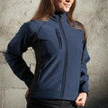 Woman wearing navy bonded softshell jacket with mock collar, front zip, chest pocket and black contrast panels