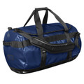 Stormtech navy blue 110L waterproof duffle bag with black webbing handles, contrast panels, and front zip pocket