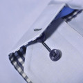 Close-up of pale blue women's shirt with navy button, contrast navy check inner collar and cuff lining