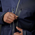 Close-up of navy Stormtech softshell jacket chest zone, showing contrast grey zip pulls, zippered chest pocket and layered panel construction