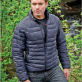 Man wearing slate grey quilted puffer jacket with stand collar, centre-front zip and chevron-stitched insulation panels, outdoors