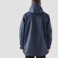 Rear view of man wearing midnight navy hooded waterproof system jacket with clean back panel and extended hem