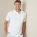 Man wearing a white cotton piqué polo with ribbed collar and two-button placket