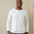 Man wearing a white long sleeve performance tee with raglan sleeves and crew neck
