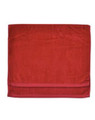 Red cotton terry velour golf towel with hemmed edges laid flat showing textured surface