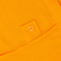 Close-up of amber gold pique polo fabric with tone-on-tone spare button patch detail