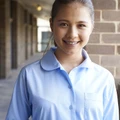 Young woman wearing a light blue long sleeve blouse with Peter Pan collar and chest pocket