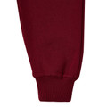 Close-up of maroon kids fleece track pants showing ribbed cuff and smooth fleece leg panel