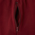 Close-up of crimson fleece track pants showing tonal zip side pocket detail